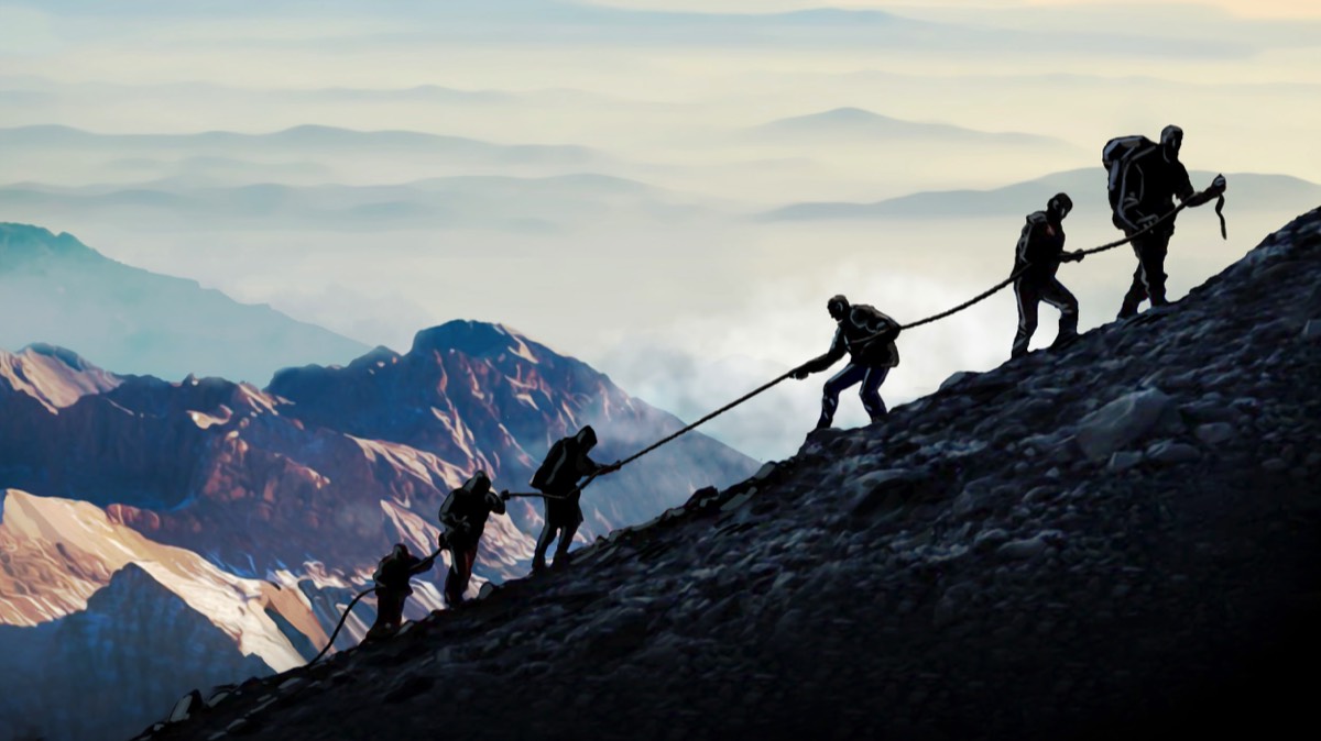 Rope team on a mountain ridge pulling each other up
